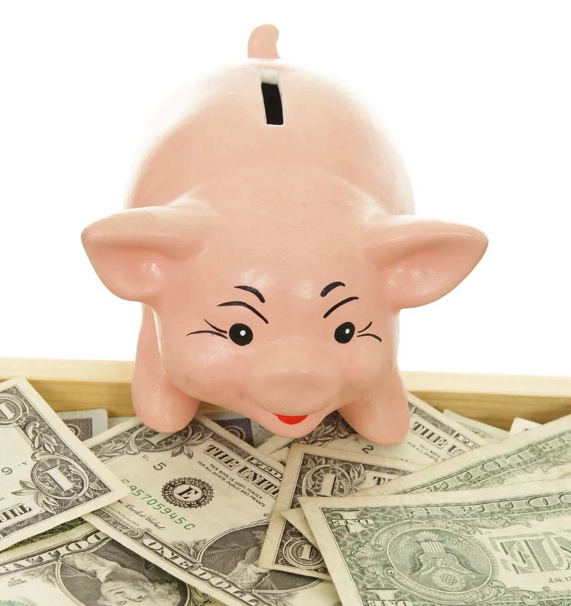 A piggy bank over several dollar bills.