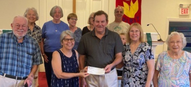 Group of older adults holding a check