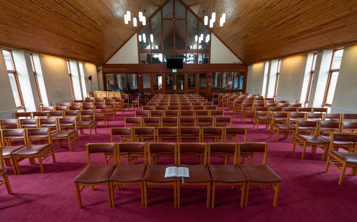 Rows of pews line the interior of a church ahead of service
