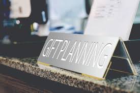 A name plate on a desk with the phrase "Gift Planning" inscribed on it