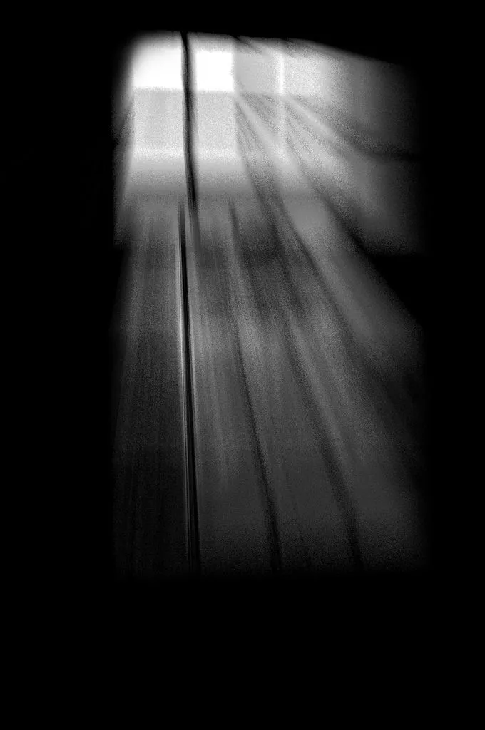 A blurry image of light coming though a barred window